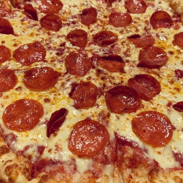 Close-up of a Mr Pizza pepperoni pizza with melted cheese and crispy pepperoni slices.